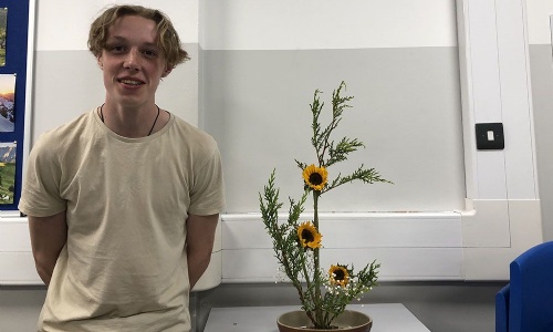 Image of a student with their Ikebana (Japanese flower arrangement)